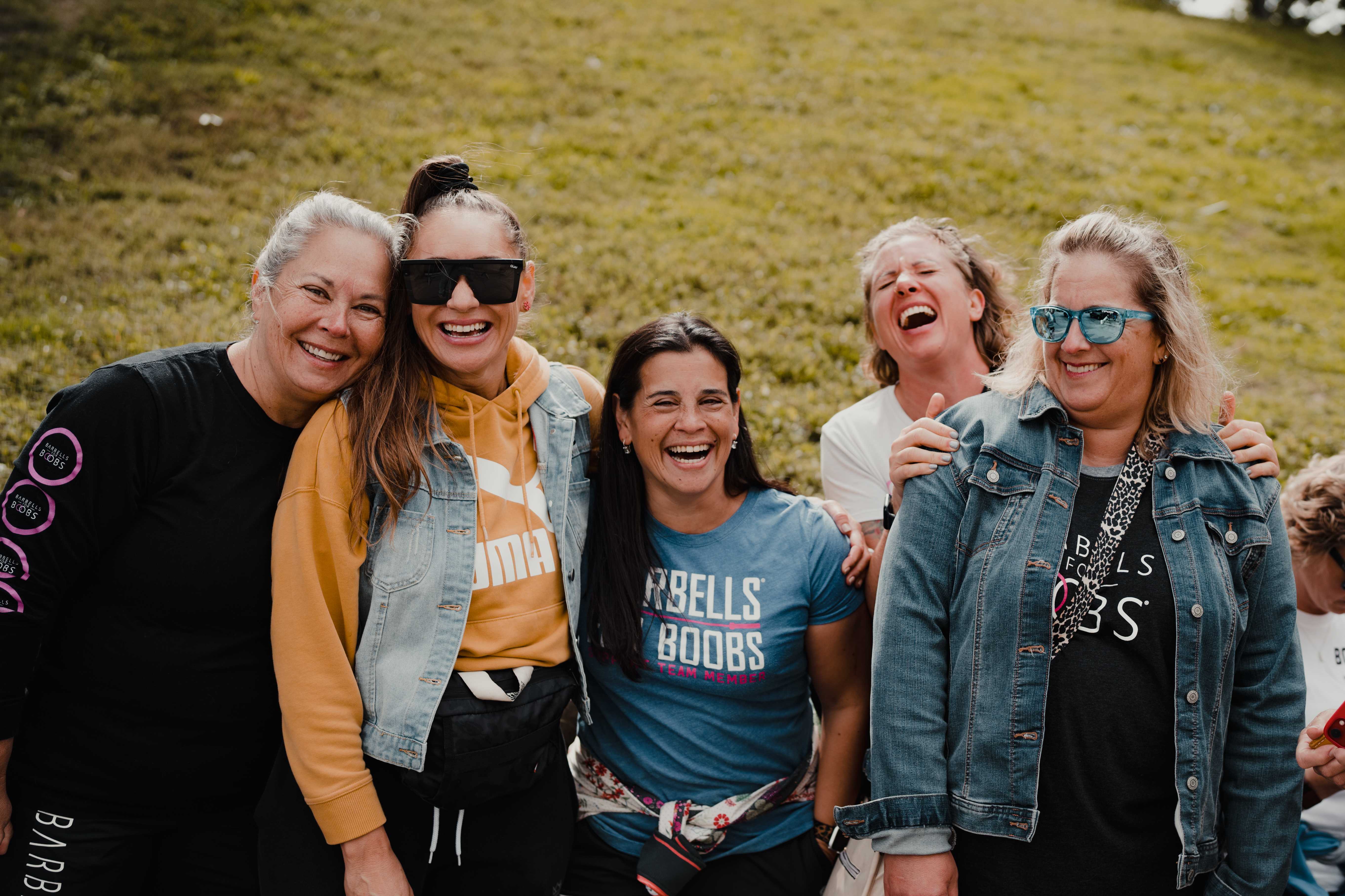 Group of women smiling and laughing at a Barbells for Boobs event